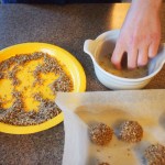 Rolling the thumbprint cookies in egg white then nuts
