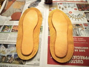 Gluing the leather insoles into the moose hide moccasins