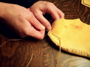 Hand sewing the moose hide moccasins together