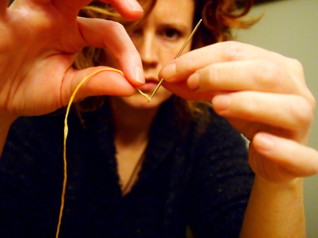 Threading the needle to stitch the moose hide moccasins 