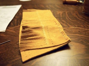 Sewing the fringe to the heel piece on the moose hide moccasins