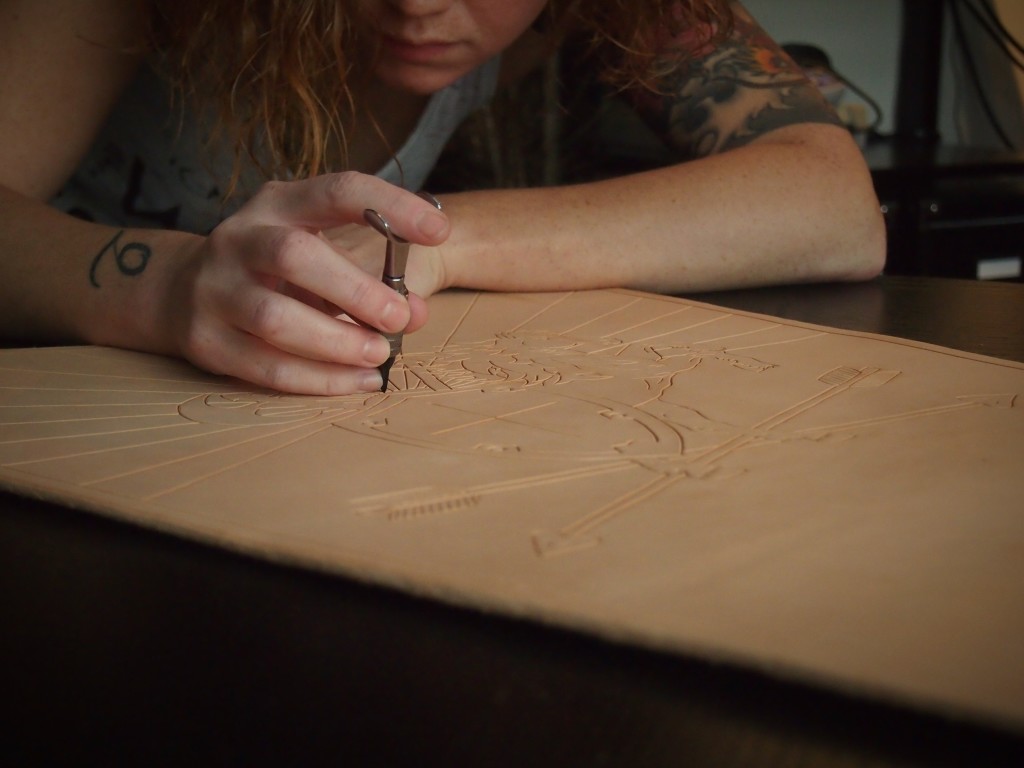 Using the swivel knife to cut out the art in the leather quiver
