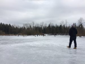 Walking on the frozen pond while the locals play hockey