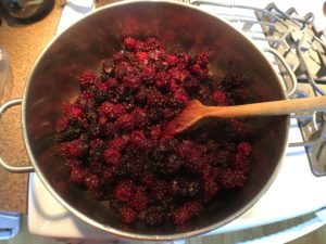 Cooking the blackberries to make homemade blackberry basil jam